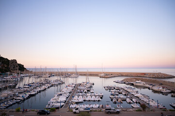 Scenic Marina at Sunset Tranquil Coastal View with Yachts and Boats. beautiful marina scene at sunset, featuring yachts and boats docked peacefully by the coast. High quality photo