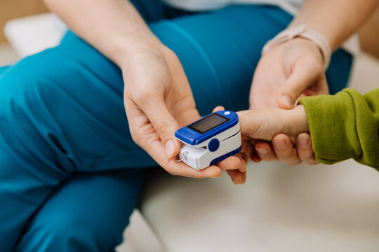 Nurse checks childs oxygen level with a pulse oximeter in a healthcare setting