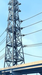 Detailed side view of towering electricity pylons with intricate steel beams against a vibrant blue sky