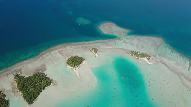 Aerial drone footage of breathtaking Rangiroa atoll in French Polynesia, vibrant turquoise water lagoon and blue deep ocean, pristine white sandbars beach, small tropical islands with palm trees motu