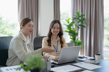 Asian office employee supervising Mentor training intern at office
