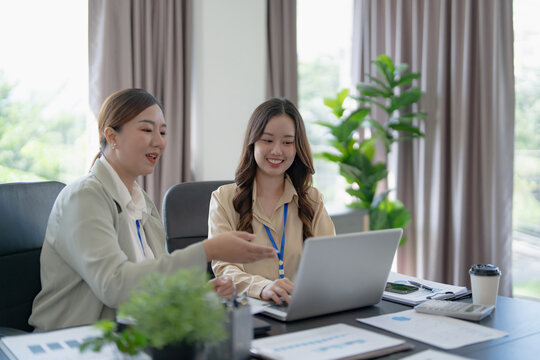 Asian office employee supervising Mentor training intern at office