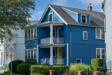 Blue clapboard family house with dormer window and balcony in Brighton, Massachusetts, USA