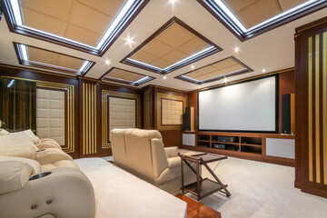Fototapeta premium Elegant interior design of a home theater in a neoclassical style. Wide screen, comfortable .chairs.