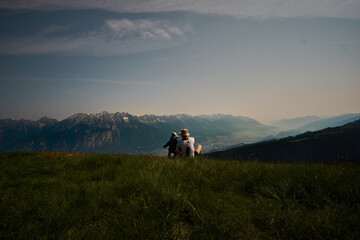 Friends enjoying a serene moment overlooking mountainous landscape during a clear day
