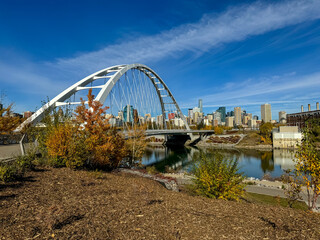 Fototapeta premium Edmonton, Alberta - October 13, 2024: Views of the Edmonton skyline with the Walterdale Bridge over the North Saskatchewan River in the foreground 