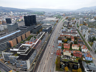 Fototapeta premium Aerial view over Swiss City of Zürich with cityscape at District of Altstetten on a cloudy autumn afternoon. Photo taken November 11th, 2024, Zurich, Switzerland.
