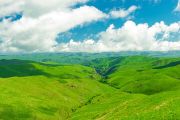 Fototapeta premium Picturesque view of small green mountains and a ravine in the mountainous area of the Caucasus