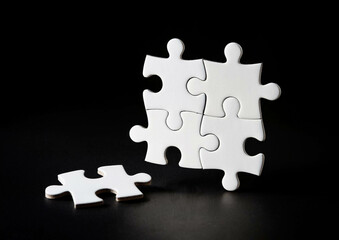 white puzzles arranged on a black background