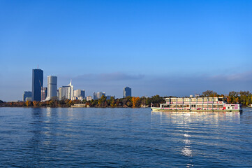 Obraz premium Panorama of Vienna with tourist ship on Danube river , Austria