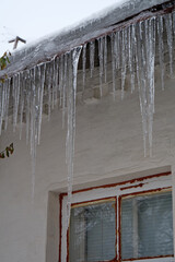 Large long icicles hang from roof of house