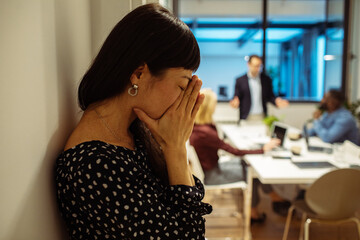 Stressed woman in workplace dealing with anxiety during office meeting