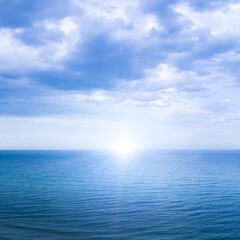 Obraz premium Calm windless ocean with the sun on the horizon.