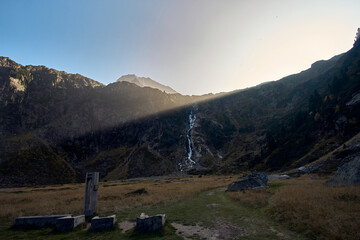 Waterfall cascades in serene mountain landscape at sunset