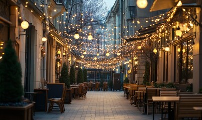Obraz premium Light garland on the street at daylight. Decoration of the street with vintage Edison bulbs garland, festive city decorations for cafe and restaurant