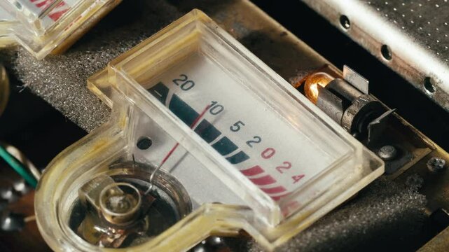 Retro sound level meter decibel meter in studio, vintage audio equipment, close up magnetic tape music player amplifier.