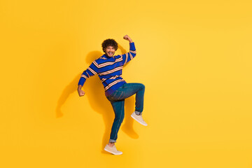 Fototapeta premium Full size photo of pretty young male winning celebrate raise fists wear trendy blue striped outfit isolated on yellow color background