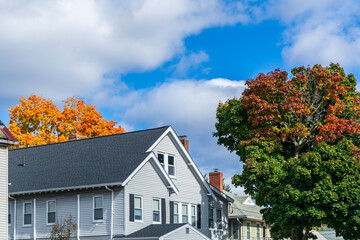 Beautiful home surrounded by colorful fall trees and sky in Brighton, Massachusetts, USA
