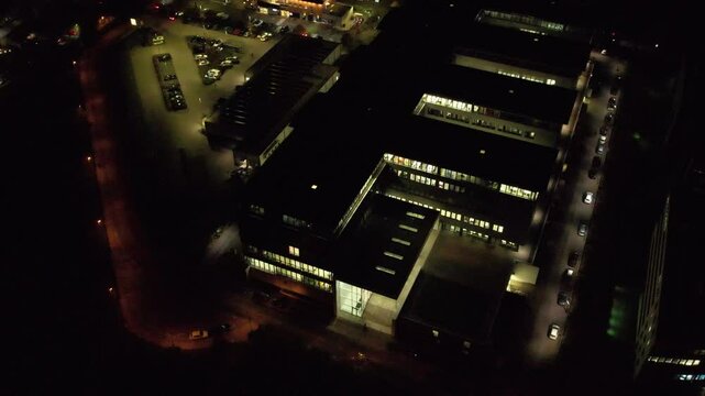 Aerial view of an office building and the nearby shopping area in Germany at night.