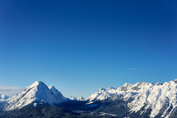 Snow-covered mountain landscape under clear blue sky in winter season