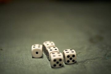 Group of six dice arranged neatly on a green tablecloth during a casual game night with friends at home