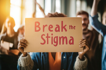 Person Holding "Break the Stigma" Sign in Group Setting