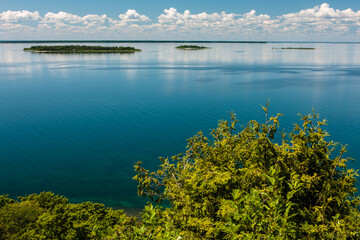 Calm water of Green Bay with its surrounding islands create a tranquil scene looking west in the early afternoon from within Peninsula State Park, Fish Creek, Door County, Wisconsin in early June