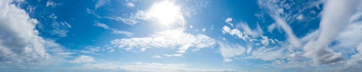 Naklejka premium Panoramic view of blue sky with clouds and sun
