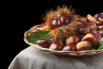 Chestnuts with leaves and burs on a wooden table