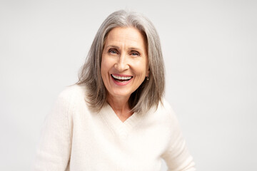 Fototapeta premium Portrait of smiling, happy gray haired, senior woman posing isolated on white background