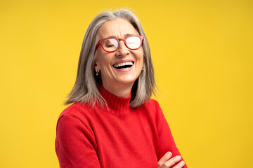 Portrait of smiling, happy elderly woman wearing stylish eyeglasses and red sweater