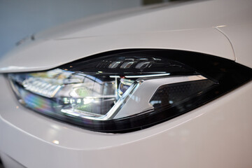 Fototapeta premium Close up of a cars headlight, part of automotive design