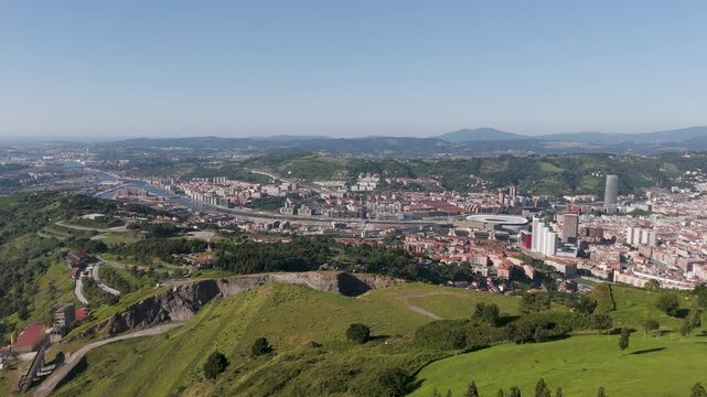Aerial footage of Mount Cobetas with a view over the city of Bilbao on a sunny day in Biscay, Spain