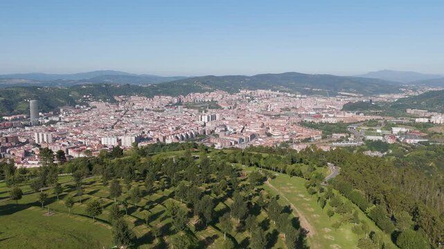 Aerial footage of Mount Cobetas with Bilbao cityscape in the background on a sunny day, Spain