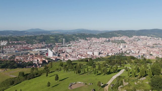 Aerial footage of Mount Cobetas overlooking the city of Bilbao on a sunny day in Biscay, Spain