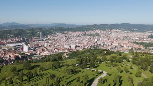 Aerial footage of Mount Cobetas overlooking the city of Bilbao on a sunny day in Biscay, Spain