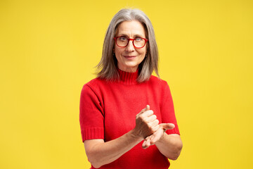 Beautiful, attractive, gray haired senior woman wearing red sweater and stylish eyeglasses