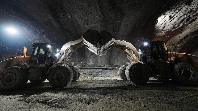 two loaders lifted buckets in tunnel construction