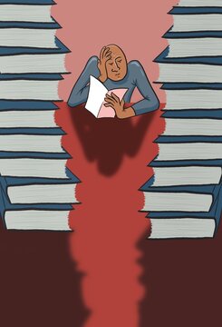 A man reading between piles of books.