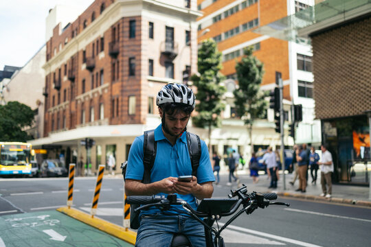 Young man using smartphone on the bike