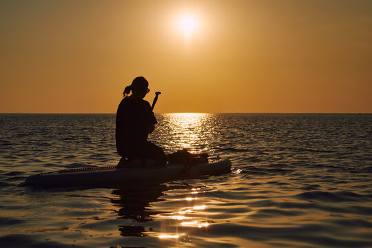 Silhouette of a paddler on calm waters during sunset