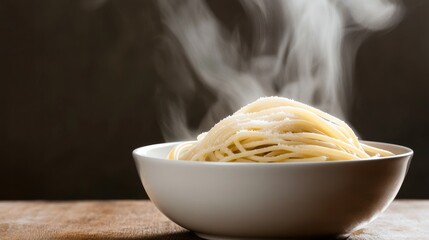 A steaming bowl of freshly cooked pasta invites a moment of culinary indulgence, with its comforting warmth rising in delicate wisps.