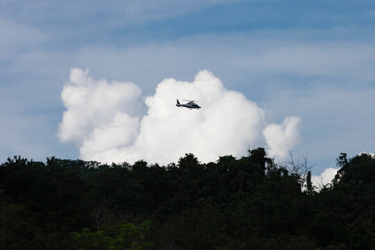 Helicopter flying past the forest