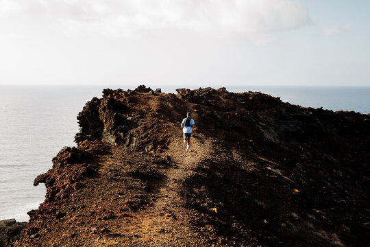 Outdoor runner hikes along the dirt roads winding through Lanzarote