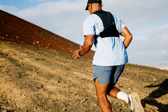 Outdoor adventurer hikes while dashing uphill on steep volcanic trail