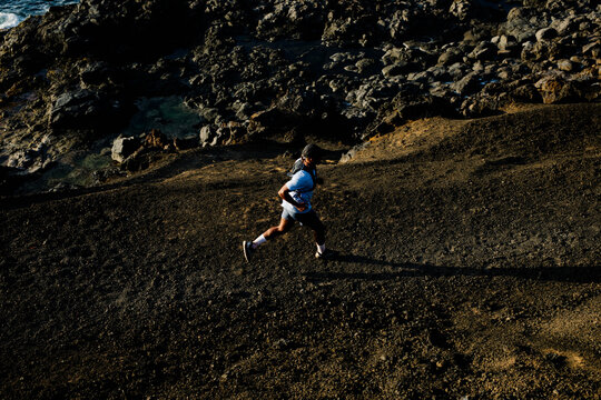 Sporty man hikes along the volcanic rock-covered paths in Lanzarote