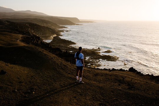Sporty man admires the coastal scenery of Timanfaya National Park