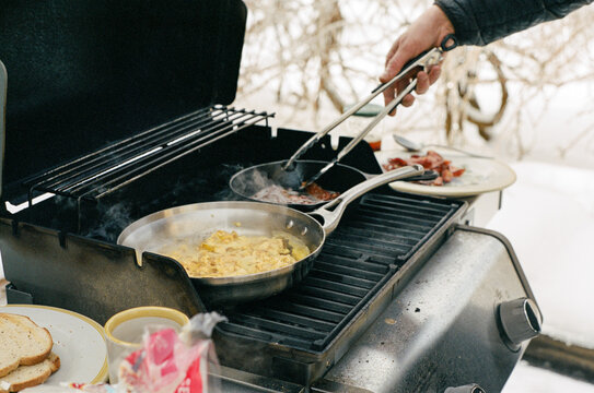 Man cooks breakfast on the grill during a winter power outage in Maine