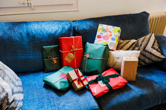 Many christmas presents waiting on the blue sofa