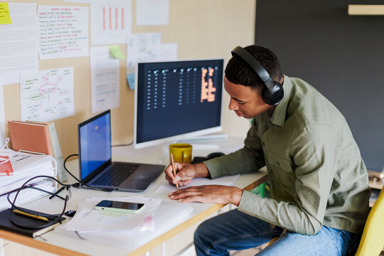 Developer is taking notes on modern office